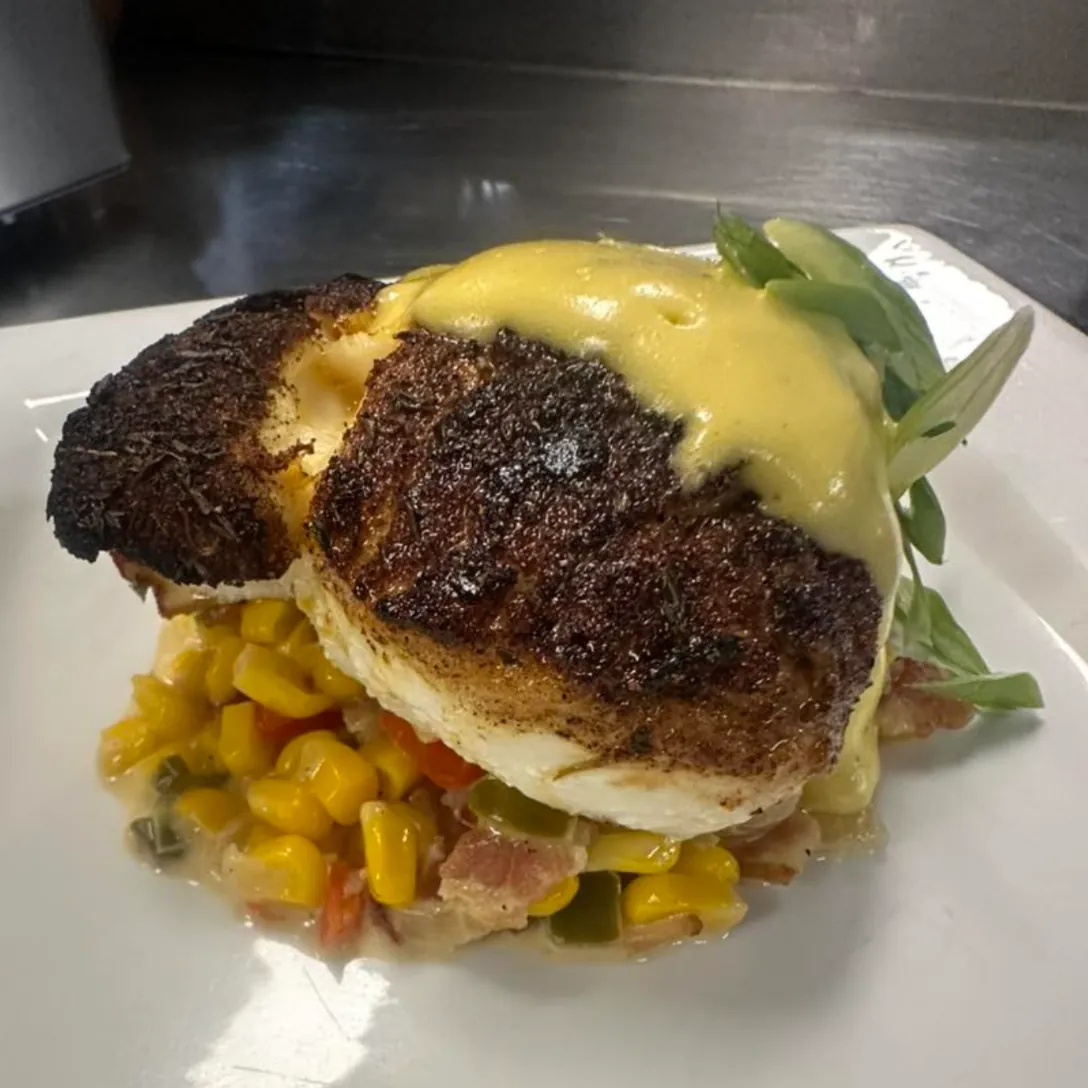 Blackened fish with hollandaise over corn succotash