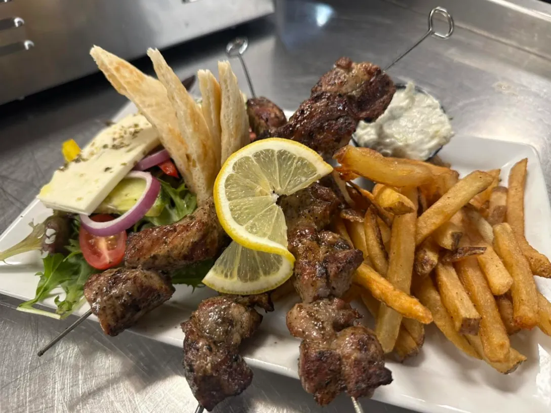 Pork souvlaki skewers with pita, Greek salad, tzatziki and fries